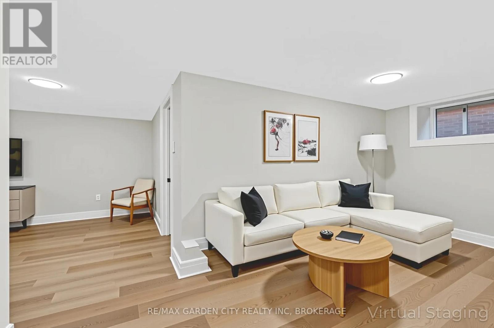 A living room with a white couch and a wooden coffee table.