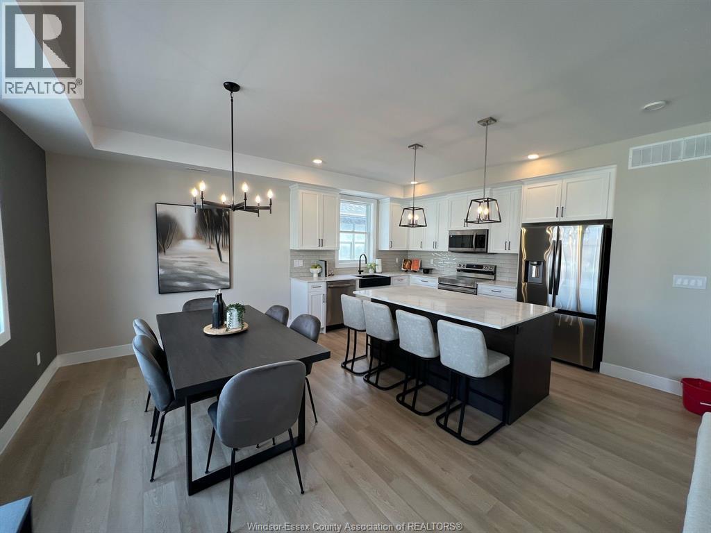 A well-lit kitchen and dining area with a large island and modern furniture.