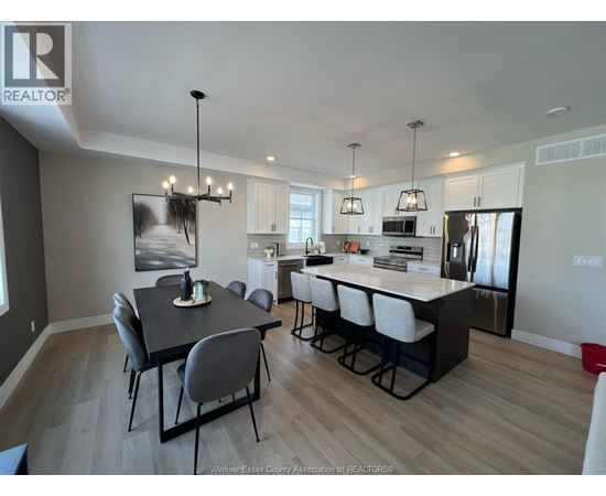 A well-lit kitchen and dining area with a large island and modern furniture.