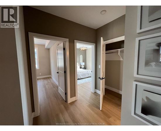 A well-lit, spacious room with a bed and a wooden floor.
