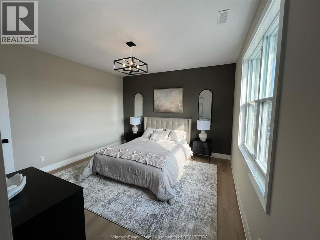 A bedroom with a large bed and a chandelier.