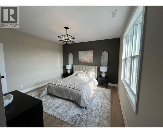 A bedroom with a large bed and a chandelier.