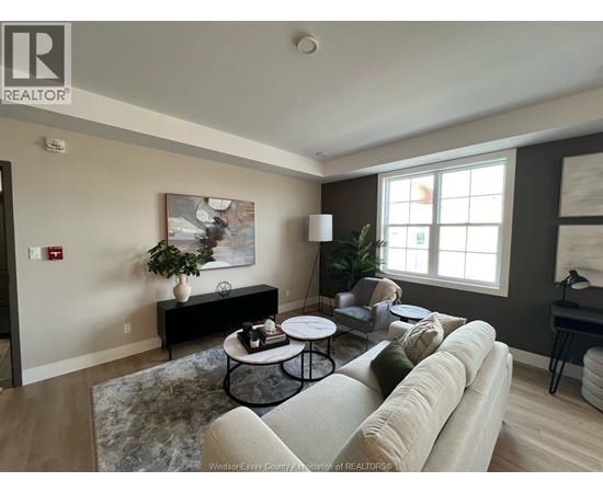 A living room with a couch, coffee table, and a painting on the wall.