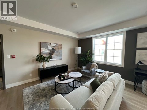A living room with a couch, coffee table, and a painting on the wall.