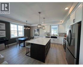 A kitchen with a refrigerator on the right side.