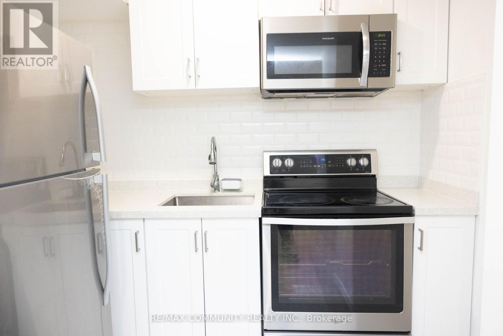 A kitchen with a stove, microwave, and refrigerator.