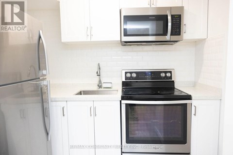A kitchen with a stove, microwave, and refrigerator.