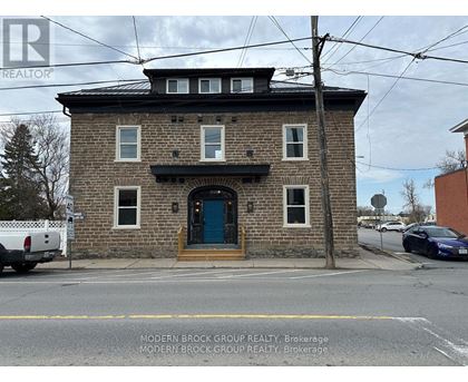 A brick building with a blue door and windows.