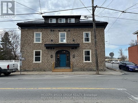 A brick building with a blue door and windows.