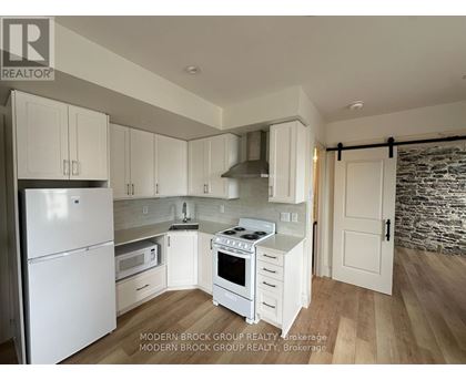 A modern kitchen with white appliances and cabinets.
