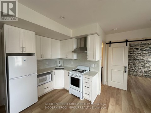 A modern kitchen with white appliances and cabinets.