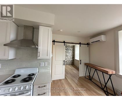 A kitchen with a stove top oven and a range hood.