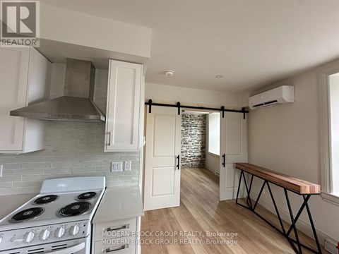 A kitchen with a stove top oven and a range hood.