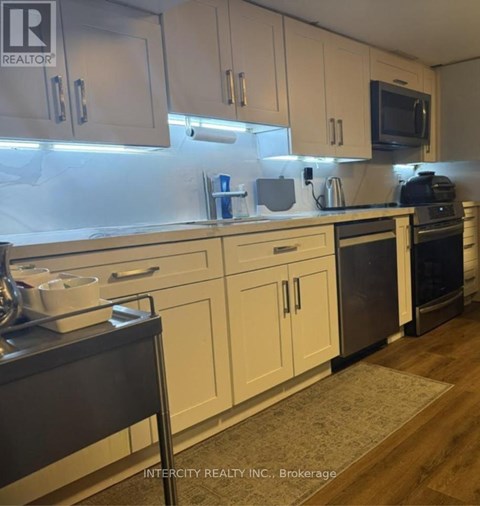 A kitchen with white cabinets and a black stove top oven.