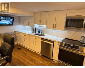 A kitchen with white cabinets and a stainless steel refrigerator.