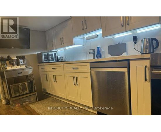 A kitchen with white cabinets and a stainless steel refrigerator.