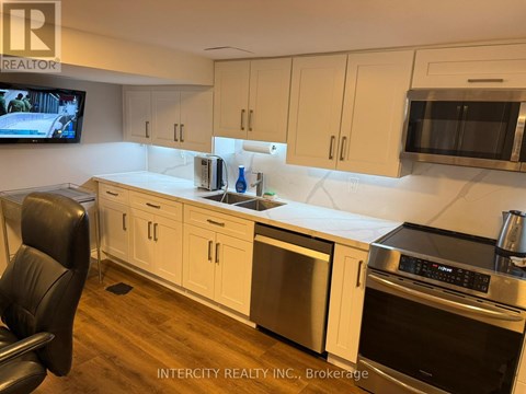 A kitchen with white cabinets and a stainless steel refrigerator.