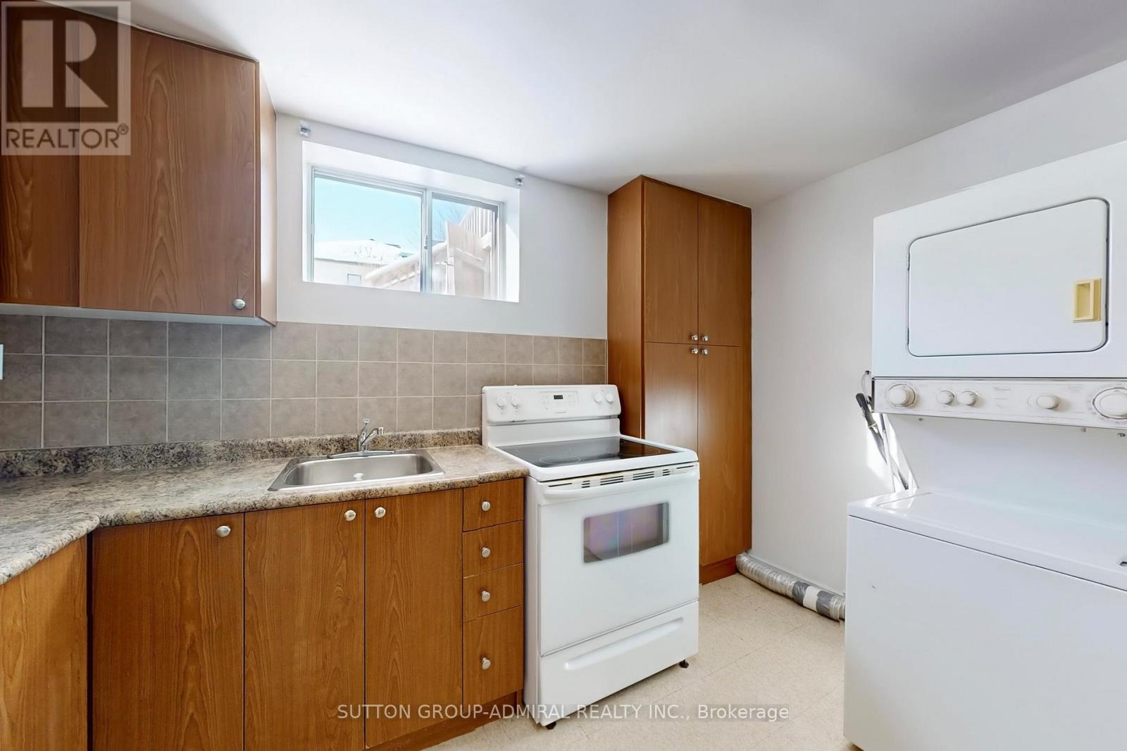 A kitchen with wooden cabinets and a white stove top oven.