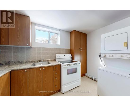 A kitchen with wooden cabinets and a white stove top oven.
