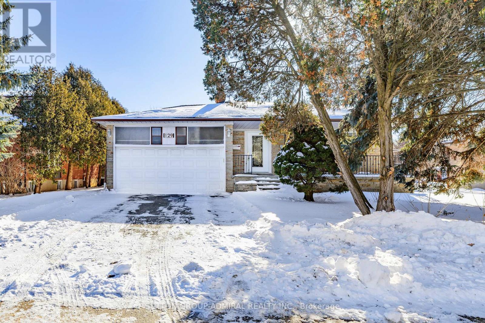 A house with a garage and a driveway covered in snow.