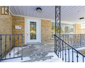 A house entrance with a white door and a black metal railing.