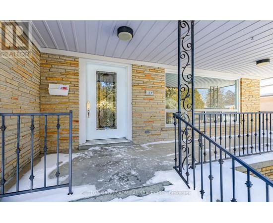 A house entrance with a white door and a black metal railing.
