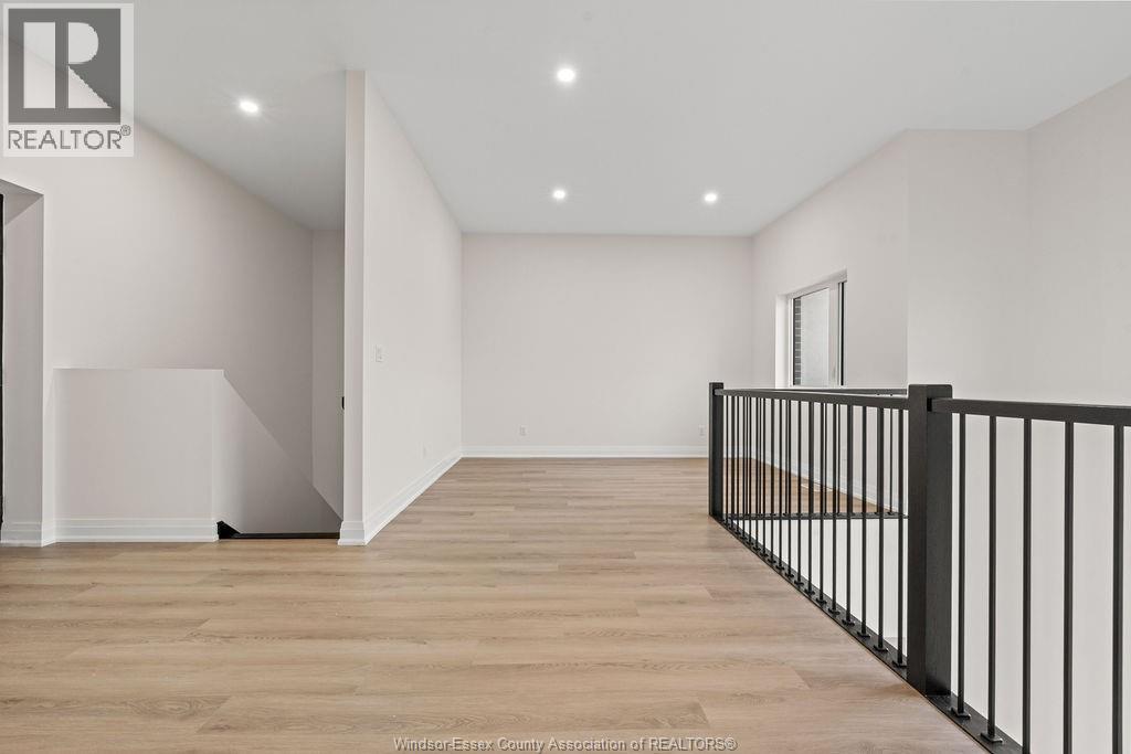 A spacious room with wooden flooring and white walls.