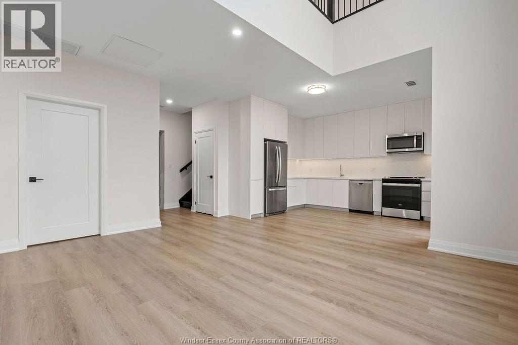 A kitchen with white cabinets and a refrigerator.