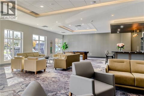 A living room with a grey carpet and beige sofas.