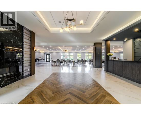 A spacious office lobby with a wooden floor and a reception desk.