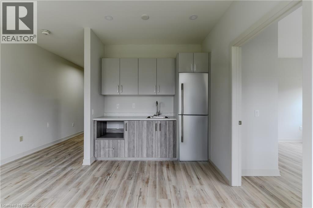A kitchen with white cabinets and a refrigerator.