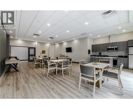 A dining room with a wooden floor and white walls.