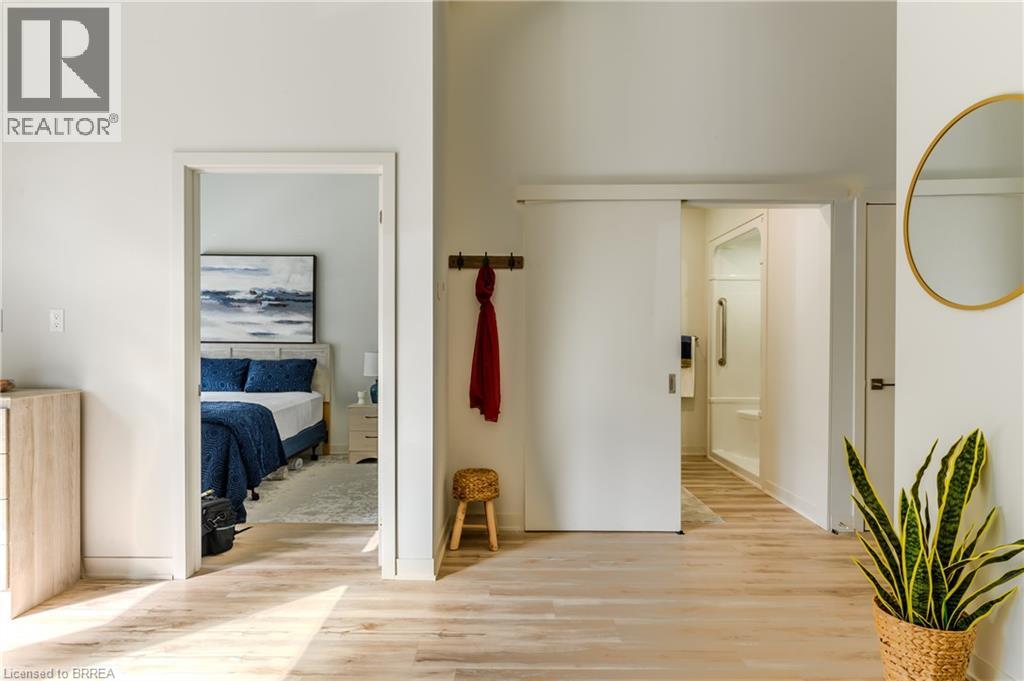 A bedroom with a bed, a chair, and a painting on the wall.