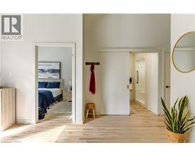 A bedroom with a bed, a chair, and a painting on the wall.