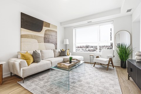 A modern living room with a large abstract painting on the wall.
