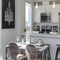 A black and white painting hangs on the wall above a kitchen island.