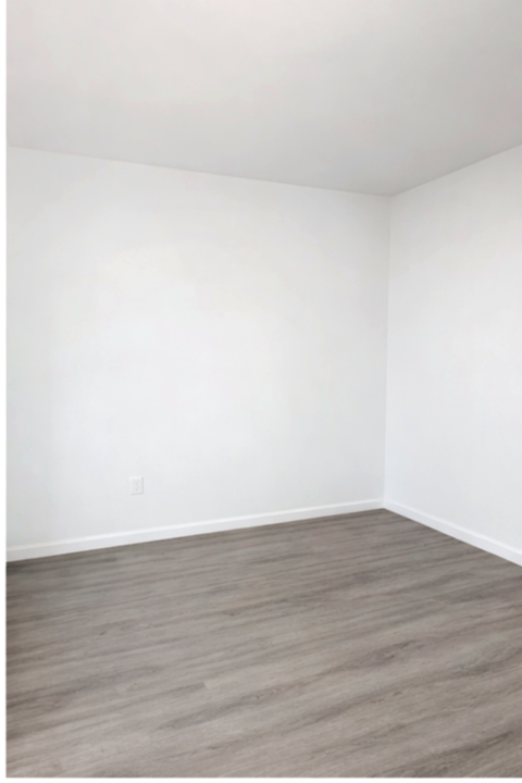 A room with a wooden floor and white walls.