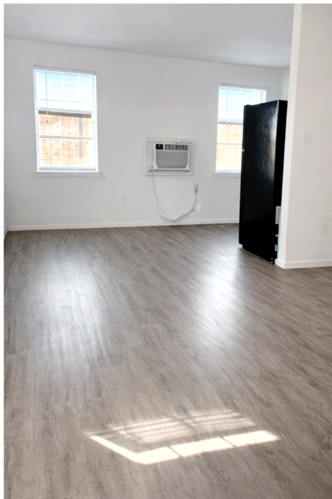 A room with a black door and a window with a white frame.
