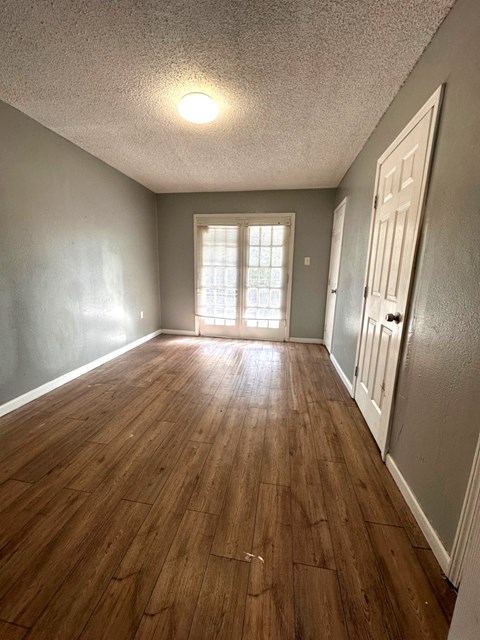 A room with wooden floors and a white door.