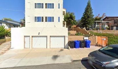 A two-story building with a garage door and a car parked in front.