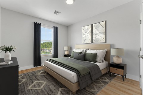 A bedroom with a large bed, a nightstand, and a window with curtains.