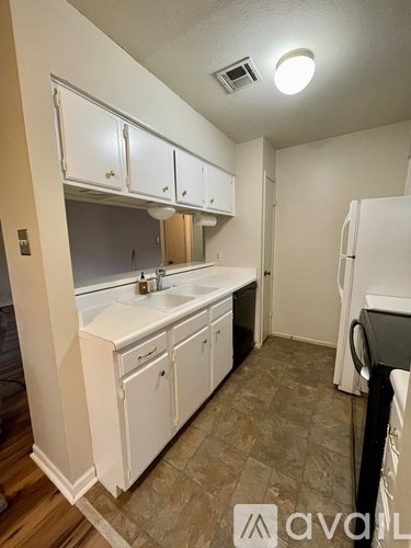 A kitchen with white cabinets and a sink.