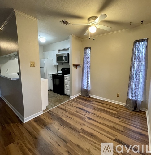 A kitchen with a refrigerator, microwave, and oven.