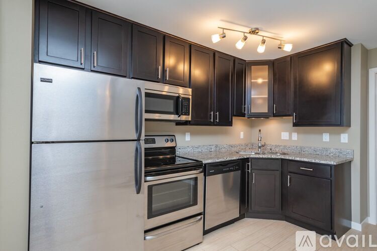 A kitchen with black cabinets and stainless steel appliances.