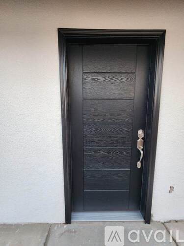 A black door with a silver handle and a silver lock.