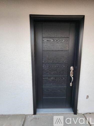 A black door with a silver handle and a silver lock.