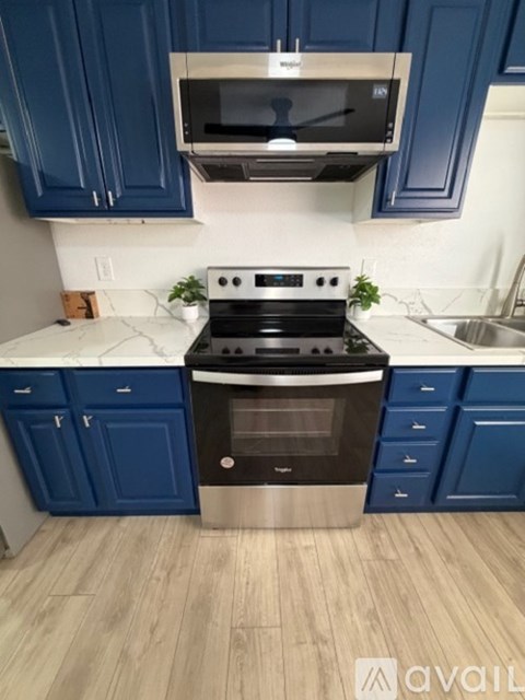 A kitchen with blue cabinets and stainless steel appliances.