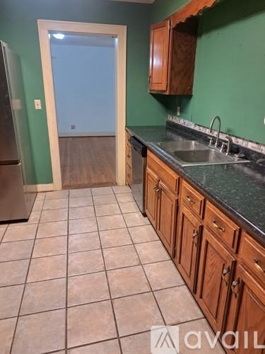 A kitchen with green walls and a tile floor.
