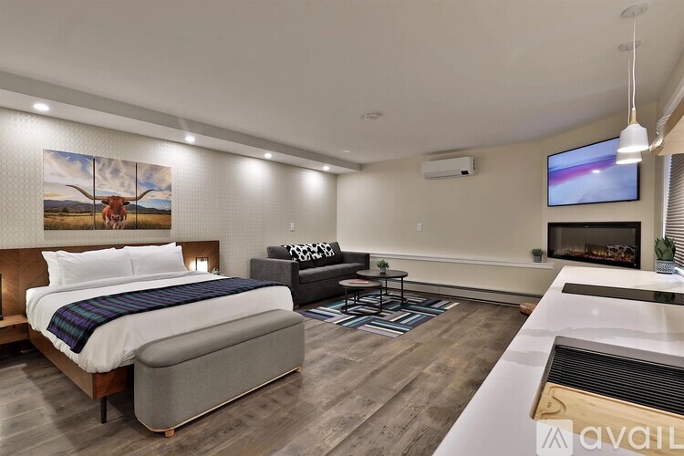 A modern bedroom with a large bed and a flat screen TV mounted on the wall.