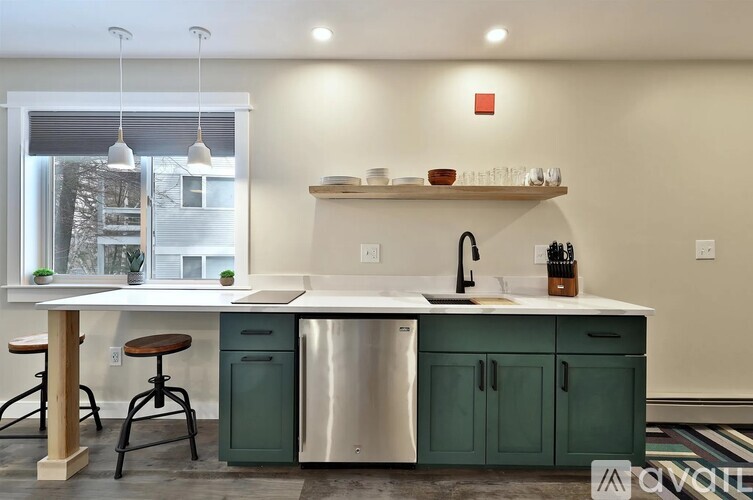 A kitchen with green cabinets and a white countertop.